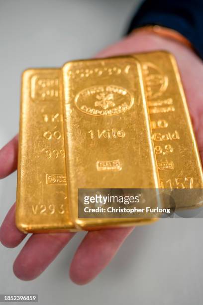 Jewellery quarter gold dealer poses with three 1kg gold bullion bars on December 13, 2023 in Birmingham, England. Gold prices have increased since...