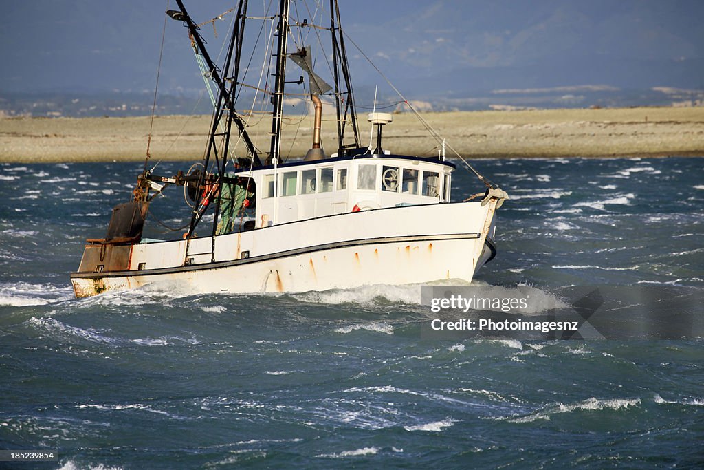 Small fishing trawler in rough seas, New Zealand