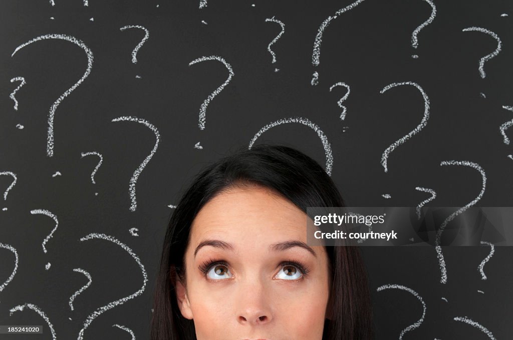 Woman with question marks on a blackboard