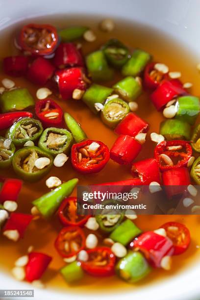 thai red and green chili in bowl of fish sauce. - nuoc cham stock pictures, royalty-free photos & images