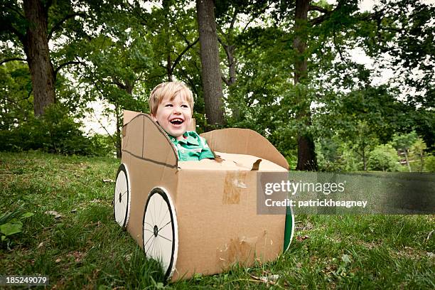 a little boy playing in a cardboard car outside - cardboard car stock pictures, royalty-free photos & images