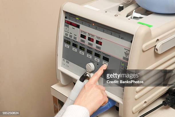 weibliche krankenschwester finger anpassen ventilator kontrolle - beatmungsgerät stock-fotos und bilder