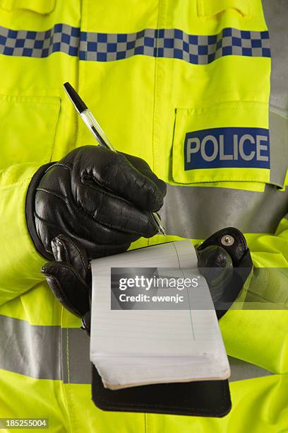 police officer jotting down details in his notepad - police uk stock pictures, royalty-free photos & images