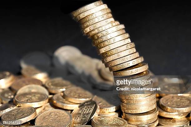 stack of one pound coins falling over - collapsing stock pictures, royalty-free photos & images