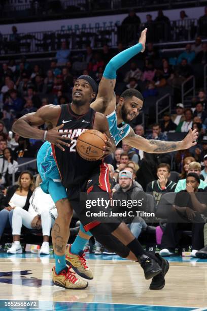 Jimmy Butler of the Miami Heat drives to the basket against Miles Bridges of the Charlotte Hornets during the second half of their game at Spectrum...