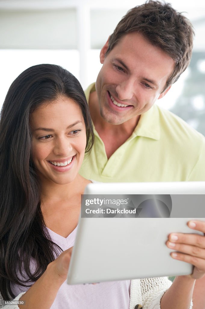 Happy couple using a digital tablet