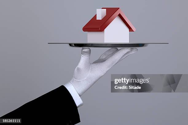 hand holding a house in tray with clipping path - formal glove bildbanksfoton och bilder