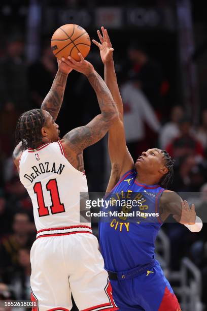 Peyton Watson of the Denver Nuggets blocks a shot by DeMar DeRozan of the Chicago Bulls during the first half at the United Center on December 12,...