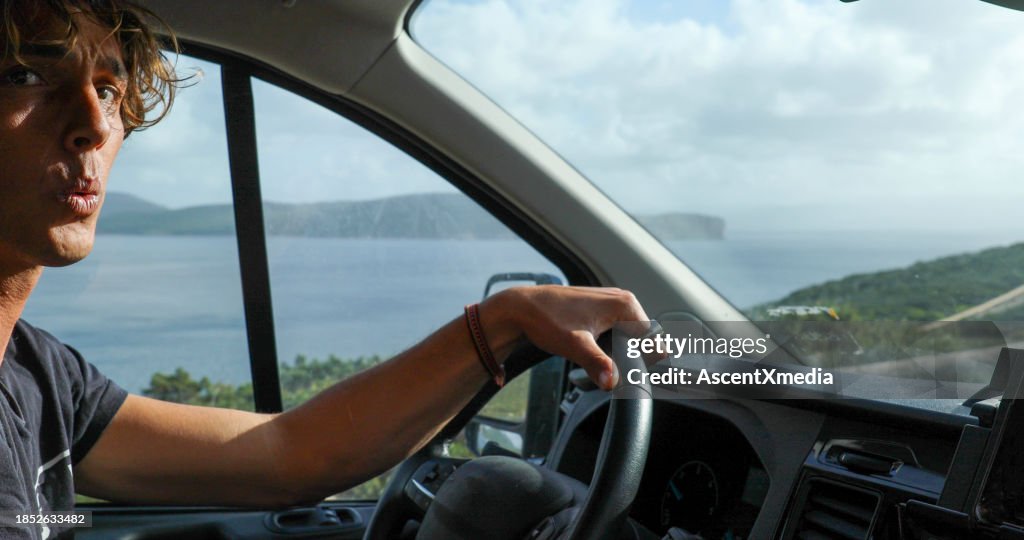 Young man drives car along the seaside