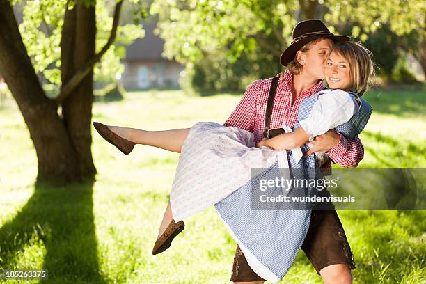 beer fest couple kissing - lederhosen stock pictures, royalty-free photos & images