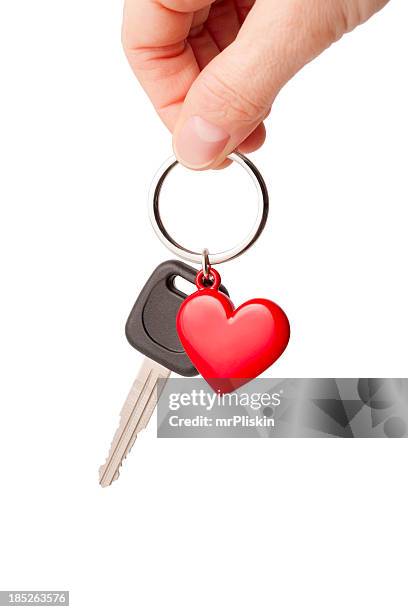 car key and heart shaped keyring - car keys hand stock pictures, royalty-free photos & images