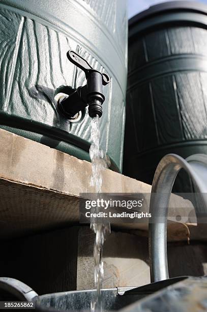 filling a watering can - rainwater tank stock pictures, royalty-free photos & images