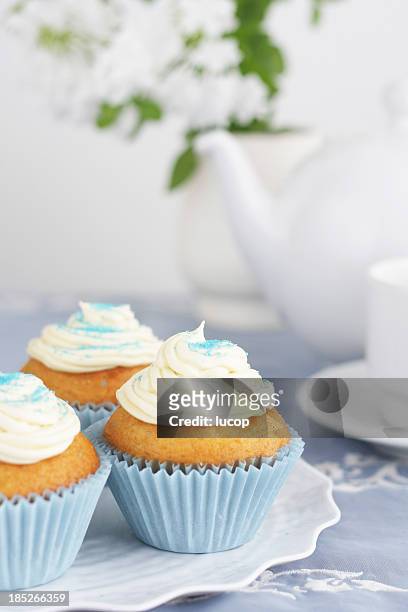 blue cupcakes with vanilla icing with tea pot and cups background - tea and cupcakes bildbanksfoton och bilder