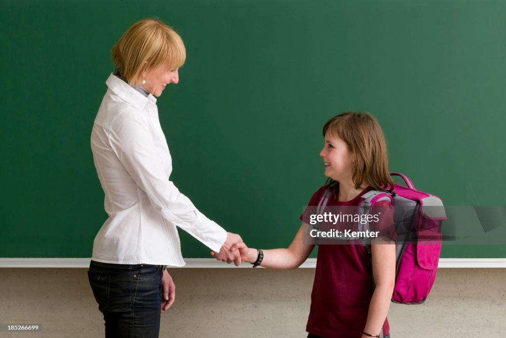 Teacher and pupil shaking hands