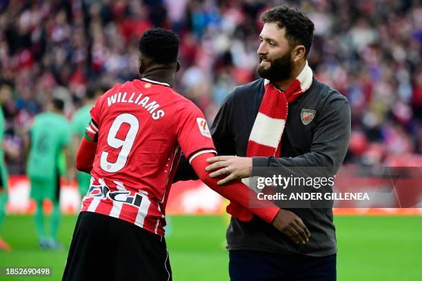 Reining Masters champion, Spanish golfer Jon Rahm shakes hands with Athletic Bilbao's Spanish forward Inaki Williams after making the honorary...