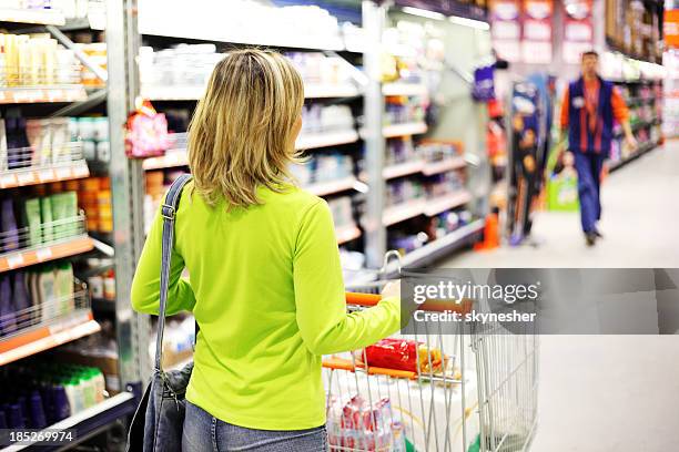 weiblich mit einem trolley gehen in großen supermarkt. - supermarkt gang stock-fotos und bilder