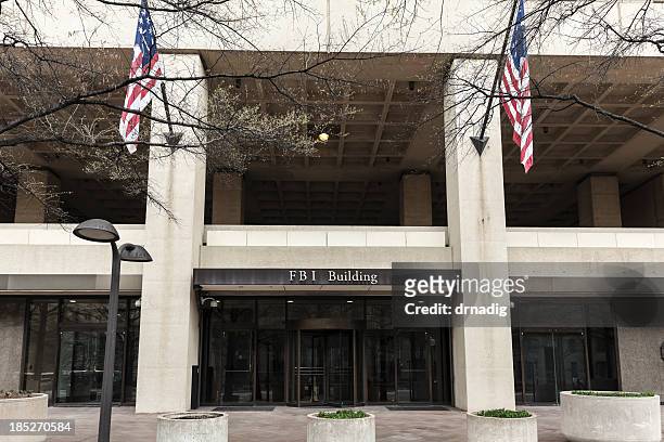 fbi building entrance flanked by flags - fbi stock pictures, royalty-free photos & images