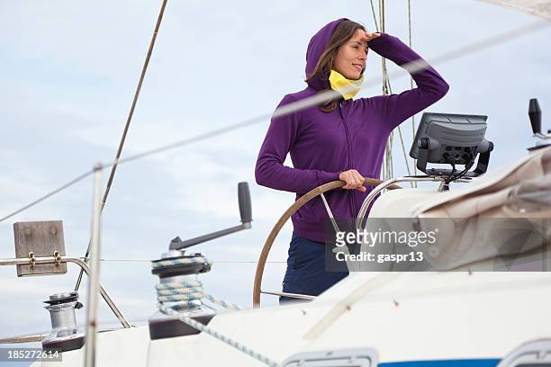 young lady skipper behind the helm - captain yacht stockfoto's en -beelden