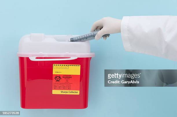 biohazard box and syringe disposal/close-up and isolated - biohazard symbol stockfoto's en -beelden