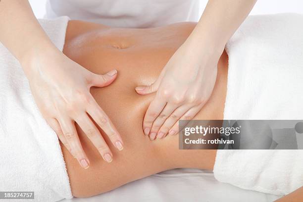 young women having stomach massage - massage therapy stock pictures, royalty-free photos & images