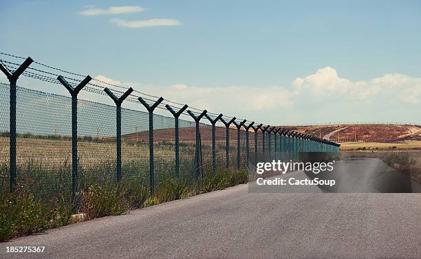 road junto a la valla - border patrol fotografías e imágenes de stock