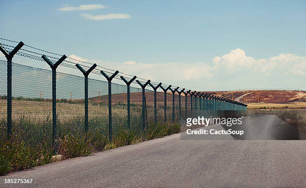 road next to a fence - segregation stock pictures, royalty-free photos & images