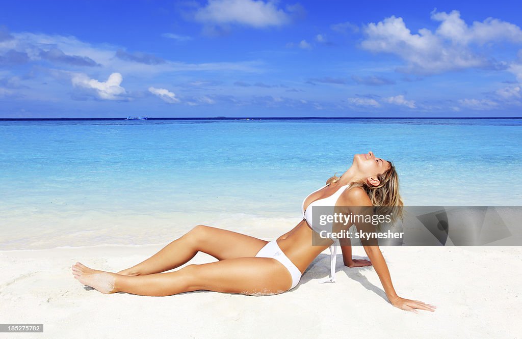 Schöne blonde Frau, die auf den Strand.