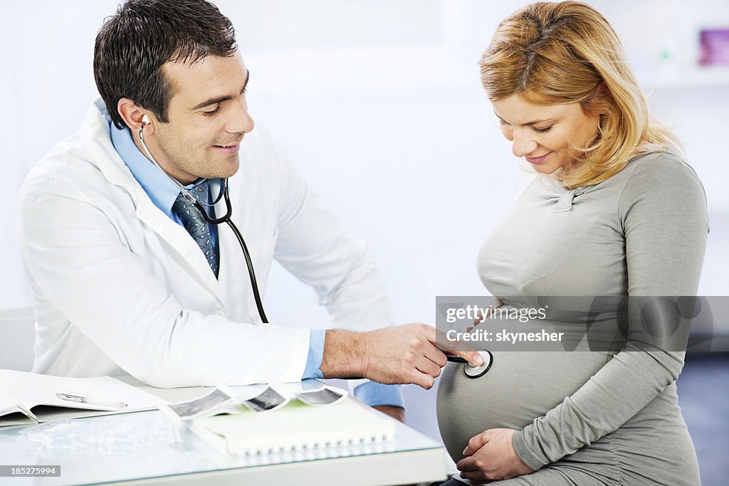 Masculino médico examinar uma mulher grávida.