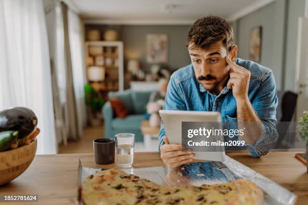 à l’aide de sa tablette numérique - en désordre photos et images de collection