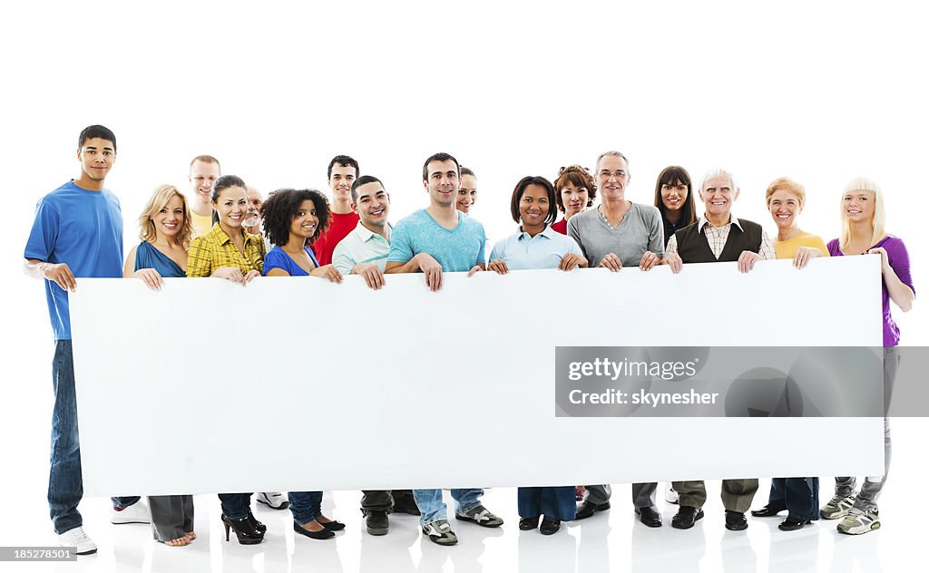 Large group of happy people holding a big white board.