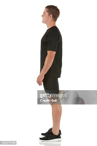 profile of a male athlete standing - running shorts stockfoto's en -beelden