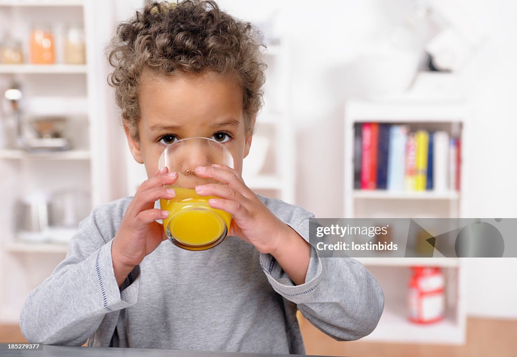 Close-up Of Biracial Toddler Drinking Orange Juice