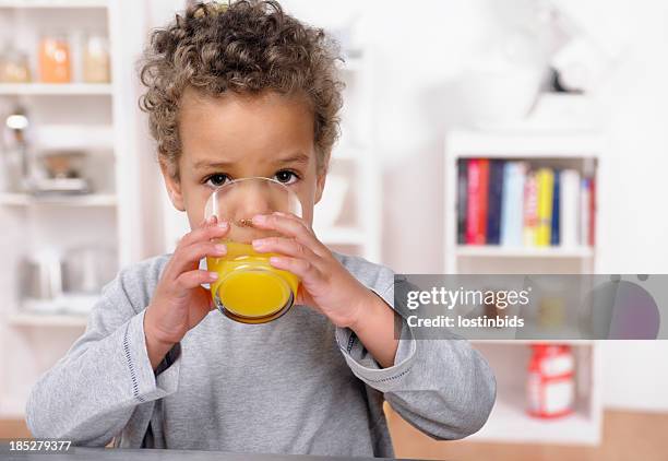 close-up of biracial toddler drinking orange juice - fruit juice drink stock pictures, royalty-free photos & images