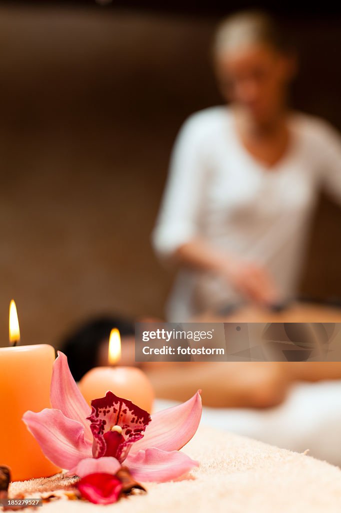 Candles and orchid on massage table