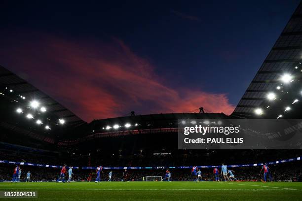 General view of play as the setting sun turns the clouds red in the sky above, during the English Premier League football match between Manchester...