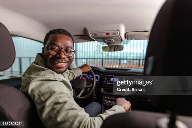 man parking his car and looking back while reversing - reversing stock pictures, royalty-free photos & images