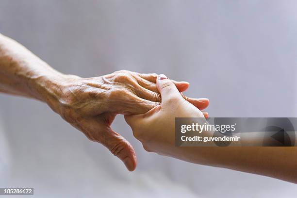 aiutando a mano - holding hands foto e immagini stock
