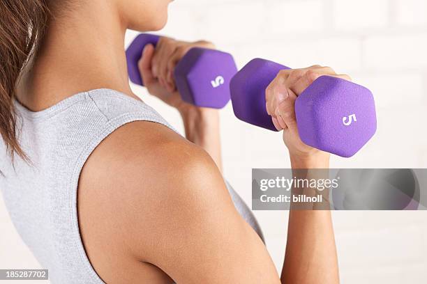 jovem mulher levantando halteres dois roxo - weight lifting imagens e fotografias de stock