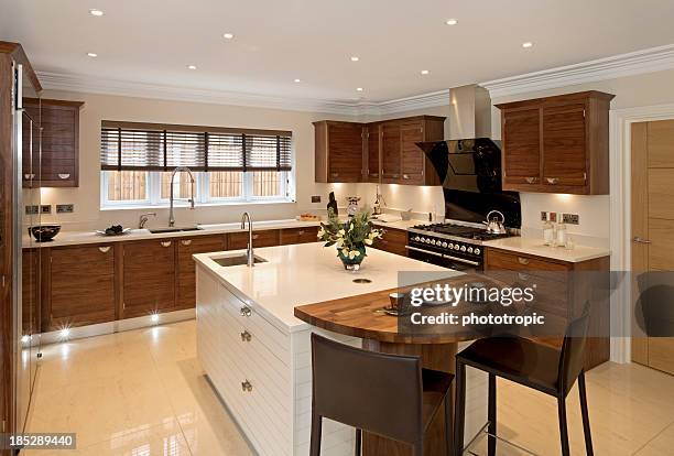 brightly-lit large modern kitchen - wooden cabinet stock pictures, royalty-free photos & images