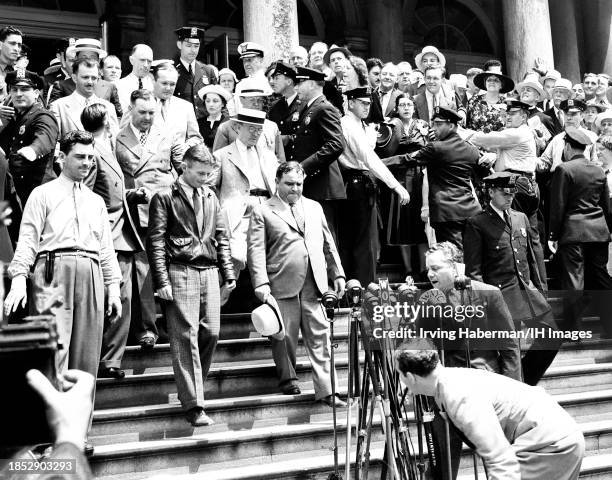 American aviator Douglas "Wrong Way" Corrigan walks down the steps of City Hall with American-Italian mayor of New York City Fiorello La Guardia in...