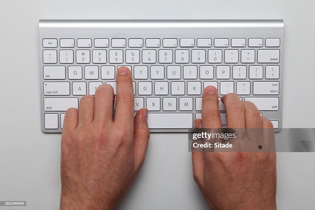 Overhead view of two hands on a keyboard