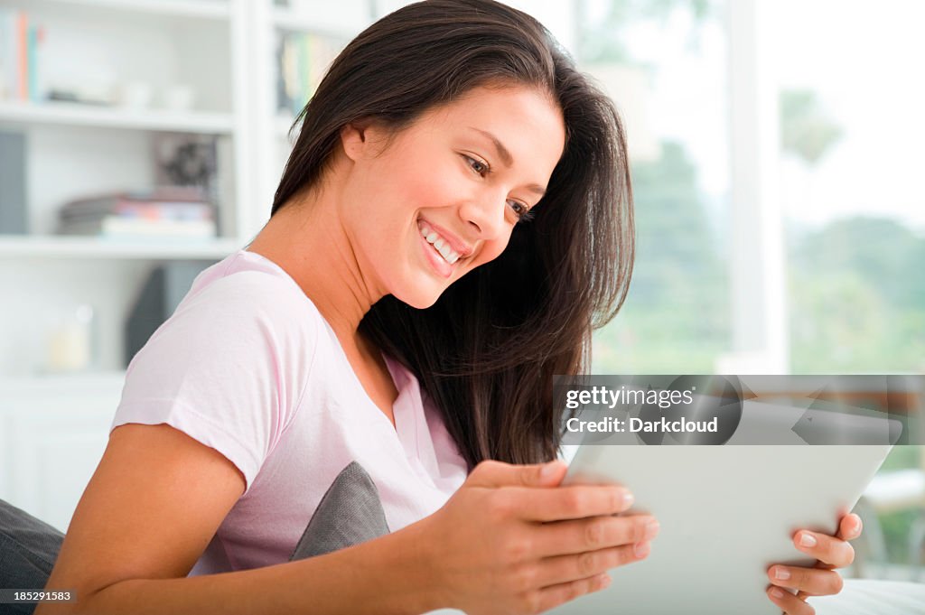 A female holding a digital tablet and smiling
