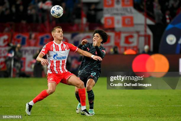 Kosta Nedeljkovic of FK Crvena Zvezda and Rico Lewis of Manchester City battle for the ball during the UEFA Champions League match between FK Crvena...