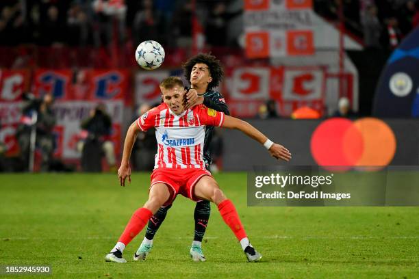 Kosta Nedeljkovic of FK Crvena Zvezda and Rico Lewis of Manchester City battle for the ball during the UEFA Champions League match between FK Crvena...