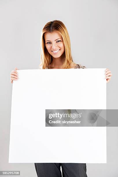 smiling young woman with sign whiteboard. - blank greeting card stockfoto's en -beelden