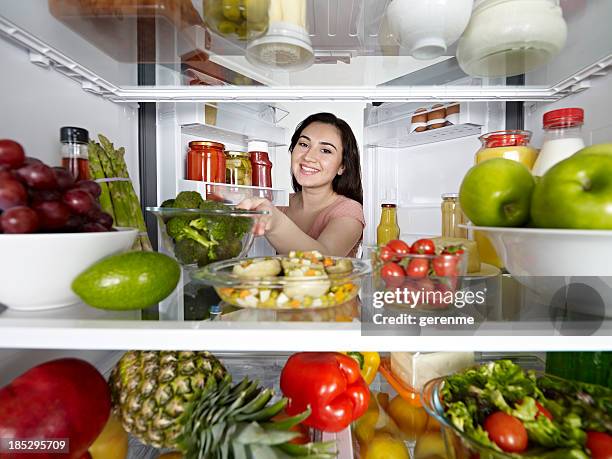 frau mit brokkoli von kühlschrank - full fridge stock-fotos und bilder