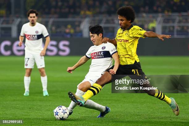 Lee Kang-In of Paris Saint-Germain is challenged by Karim Adeyemi of Borussia Dortmund during the UEFA Champions League match between Borussia...