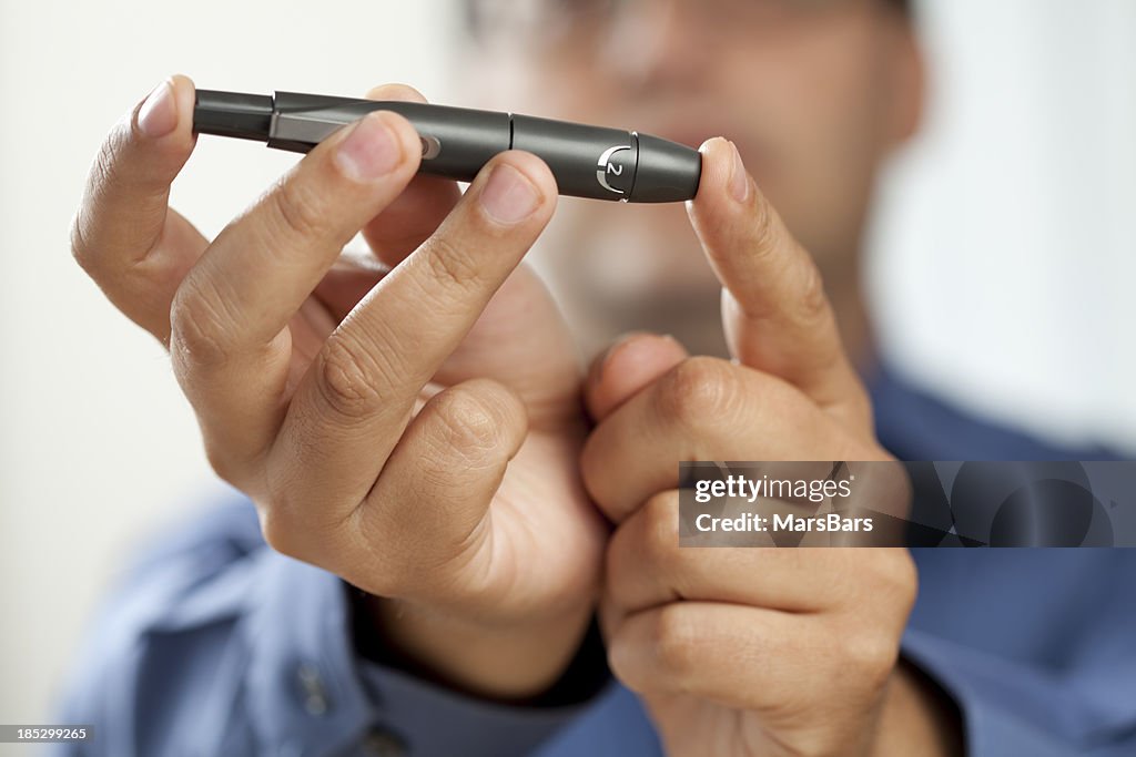 Diabetic man pricking finger for glucose test