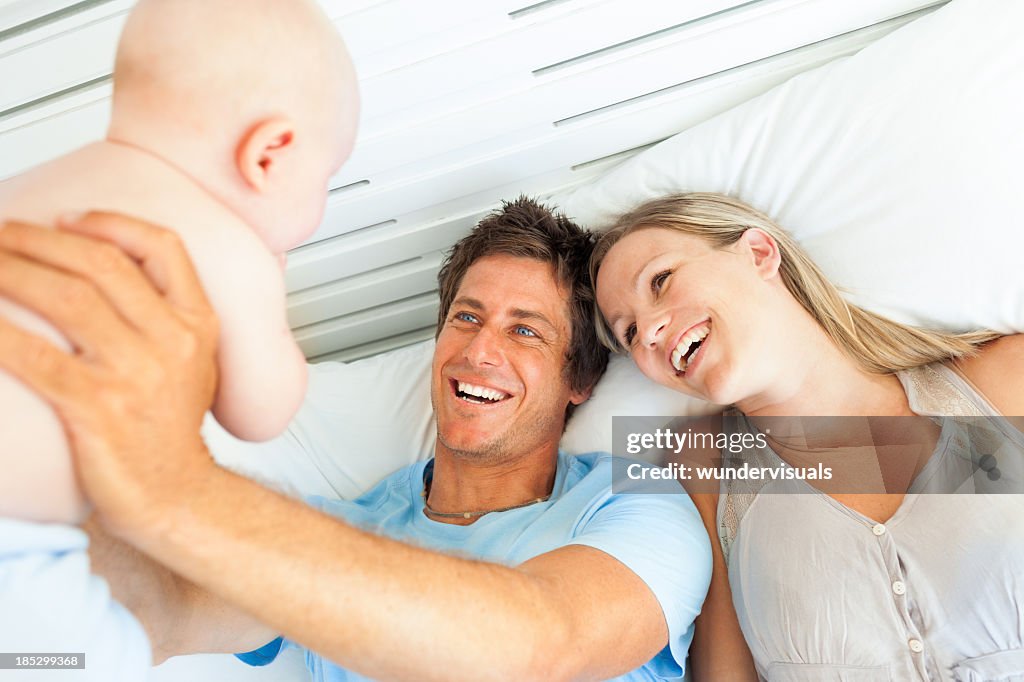 Parents Playing With Baby In Bed