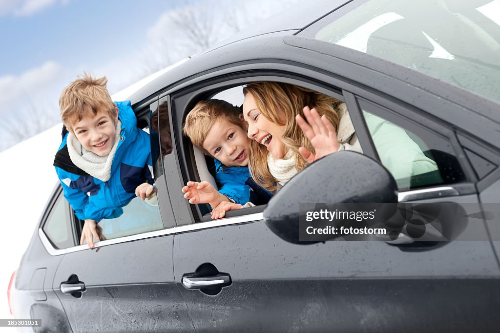 Happy family in the car on winter day